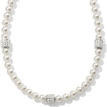 A Meridian Petite Pearl Station Necklace composed of small white pearls is adorned with three cylindrical, silver, and jeweled spacers, positioned evenly around the strand in a studio setting.