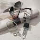 Pretty Tough Apple Watch Band shown with complimentary bracelet, ring and sunglasses on newspaper