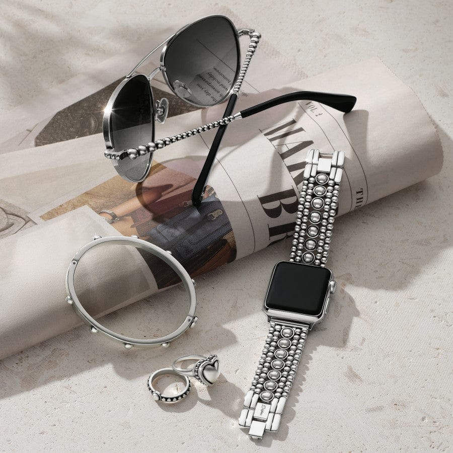Pretty Tough Apple Watch Band shown with complimentary bracelet, ring and sunglasses on newspaper